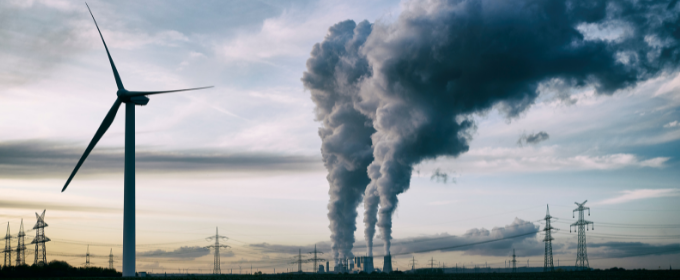picture of a windmill and a factory emitting smoke